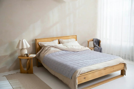 chambre minimaliste avec lit en bois clair et lampe de chevet blanche