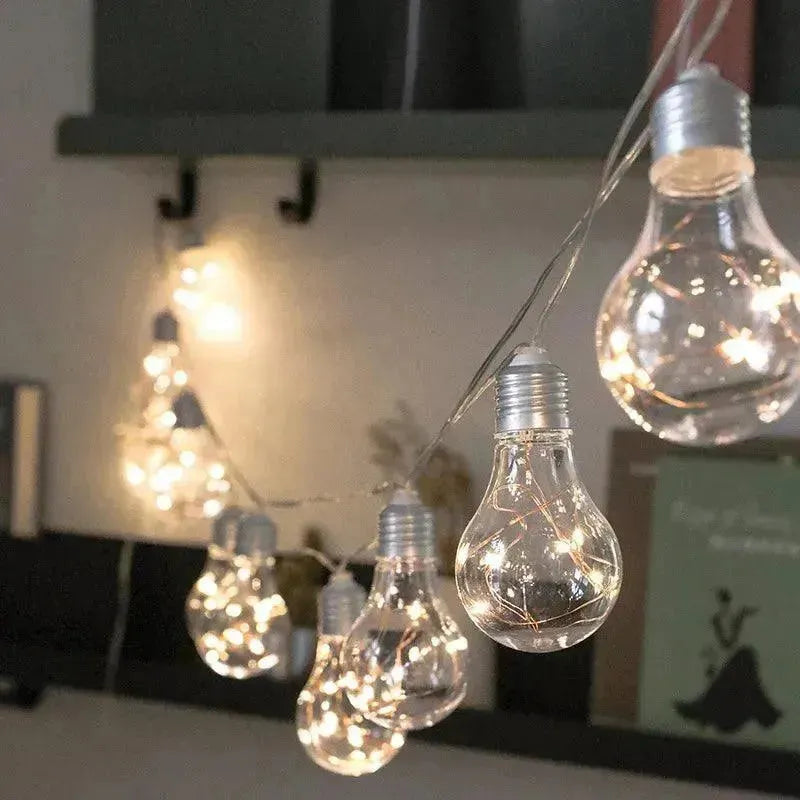 guirlande ampoule culot argenté  accrochée entre un mur et une étagère