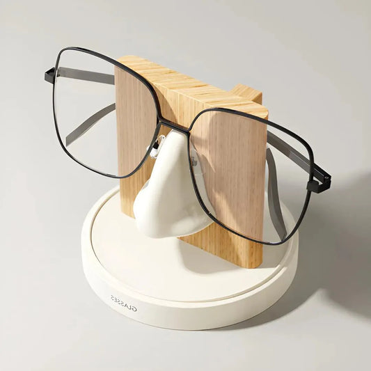 support lunettes blanc et bois clair avec paire de lunettes noire sur fond neutre