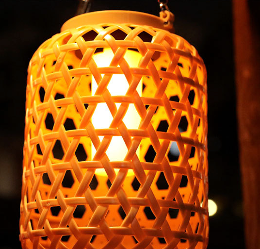 zoom lampe exterieure tiki effet bambou allumée le soir et suspendue