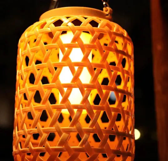 zoom lampe exterieure tiki effet bambou allumée le soir et suspendue