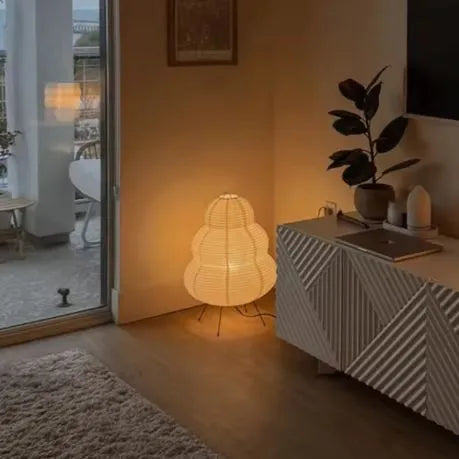 lampe en papier dans le coin d'un salon à coté d'un meuble télé