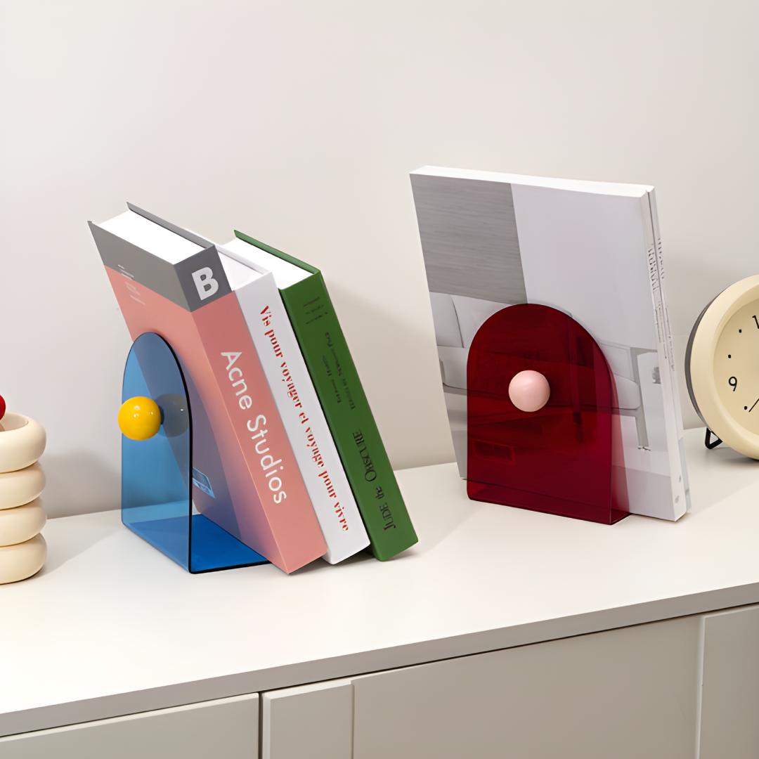 Bloc livres bleu avec boule jaune et bloc livres rouge avec boule rose, utilisés pour caler des livres sur une étagère