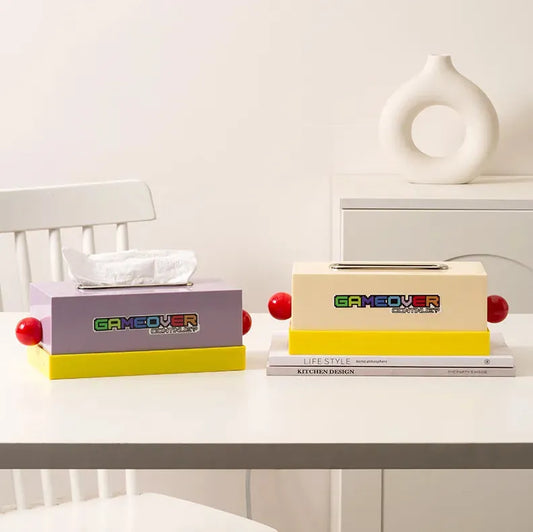 boite à mouchoir style memphis une blanc cassé l'autre mauve posé sur une table sur un fond blanc assez neutre