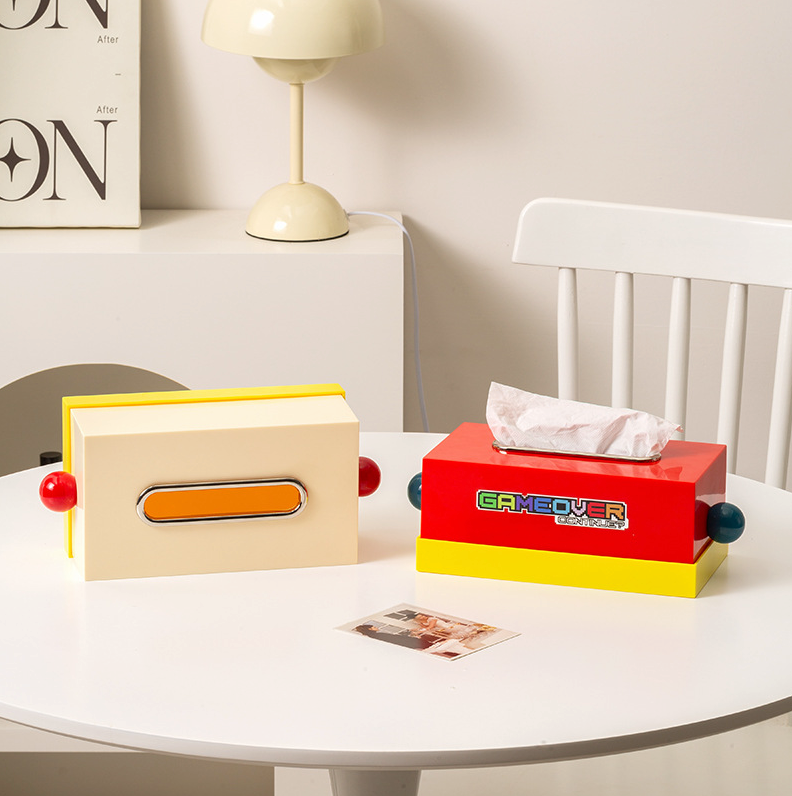 boite à mouchoir style memphis une blanc cassé l'autre rouge sur table blanche avec lampe flowerpot blanche en arrière plan