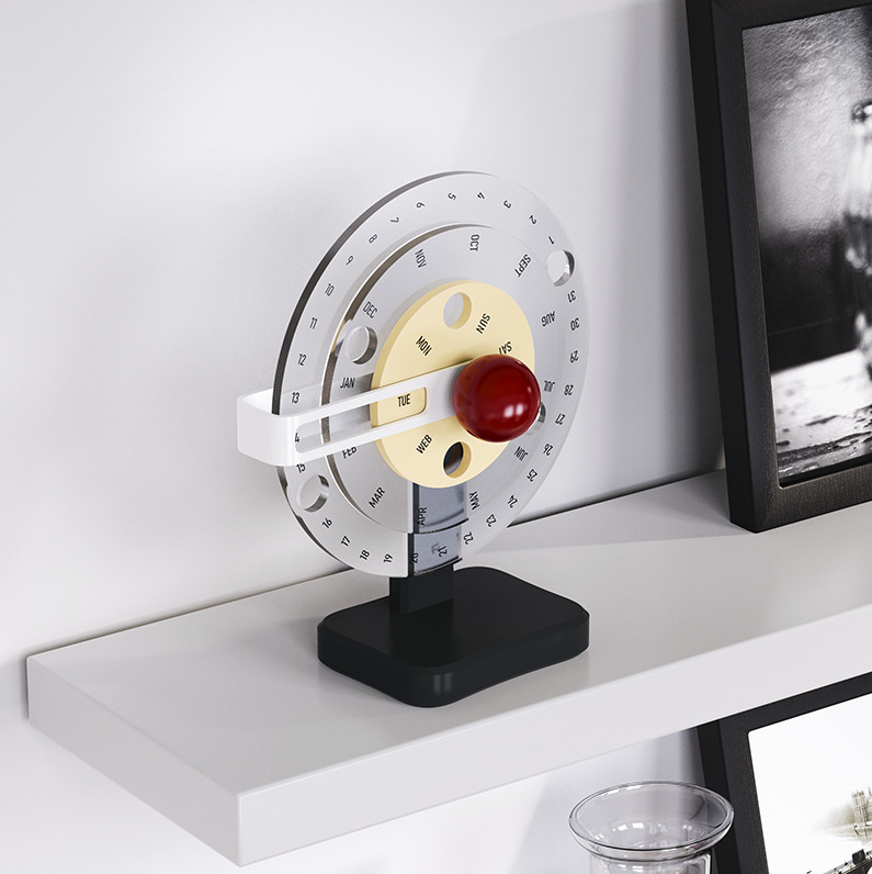 calendrier rotatif couleur clair 3 cercles sur une étagère à coté d'un cadre