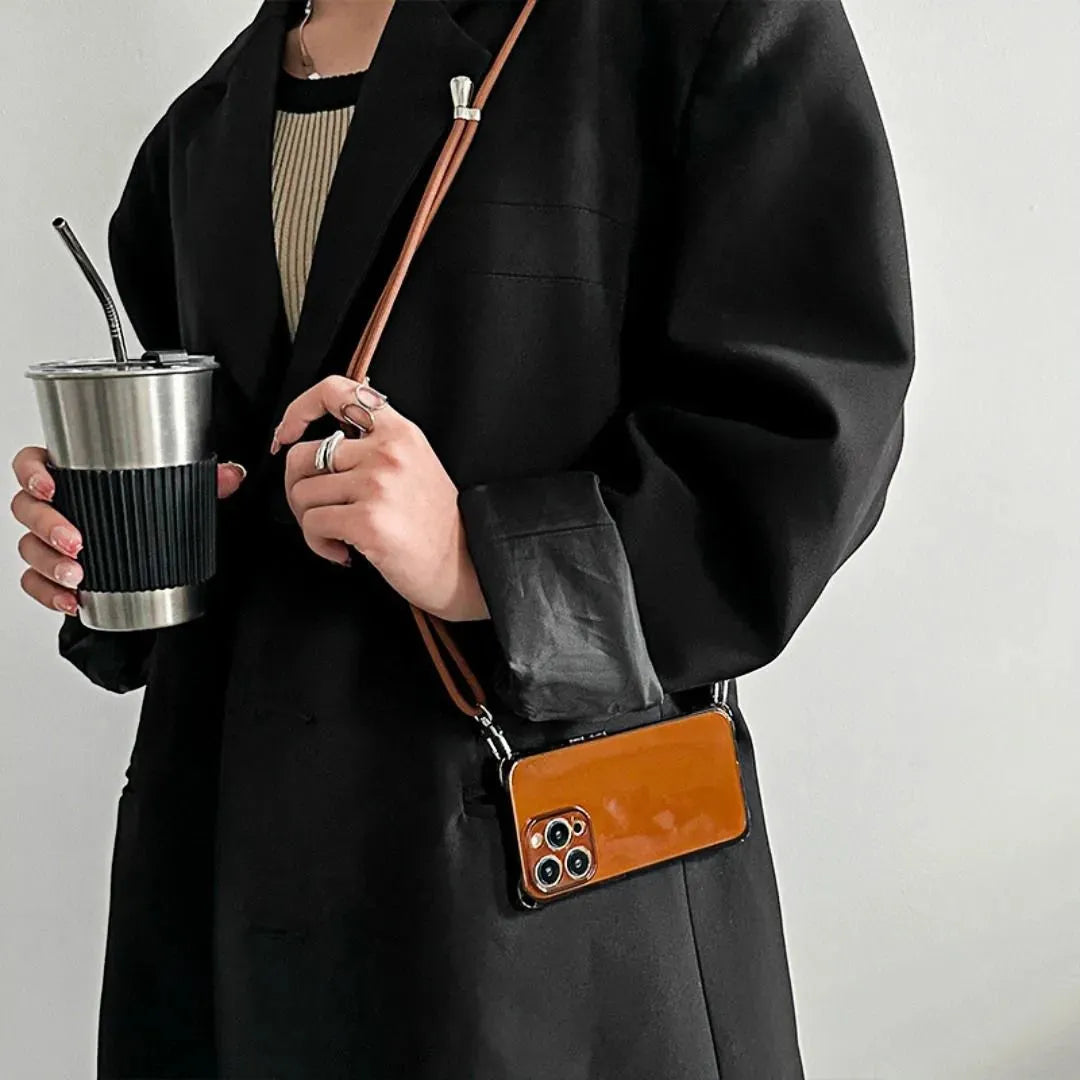 Coque iPhone marron portée en bandoulière, femme tenant un gobelet inox
