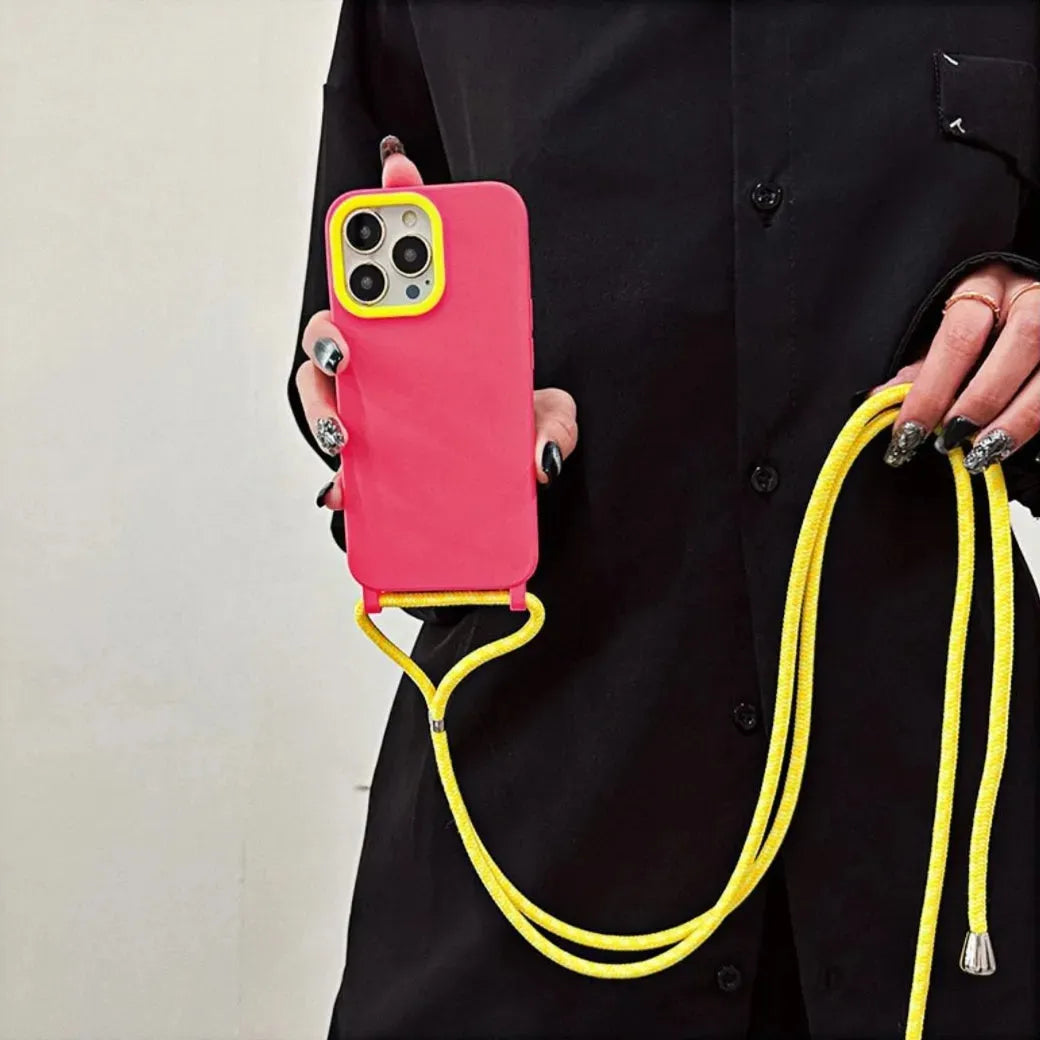 Coque iPhone rose avec contour caméra jaune – vue de face, tenue par le cordon