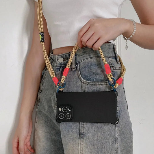 Coque noire tenue en main, portée sur le côté avec cordon jaune quadrillé à double nœud rose