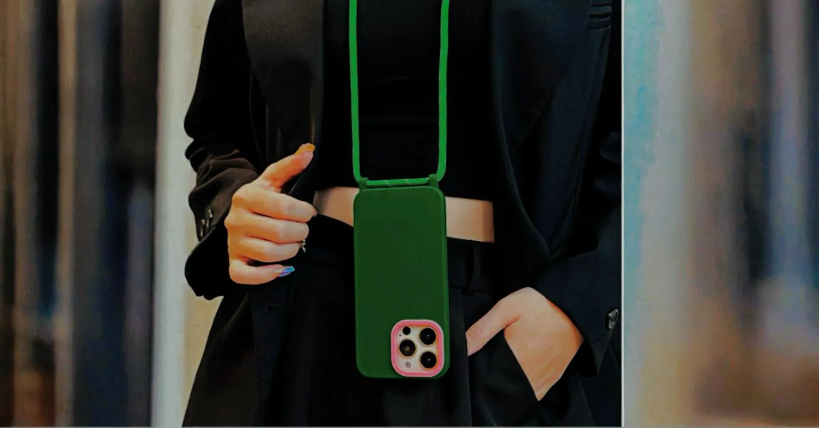 Photo lifestyle verticale, coque verte portée avec une tenue noire chic, ambiance urbaine