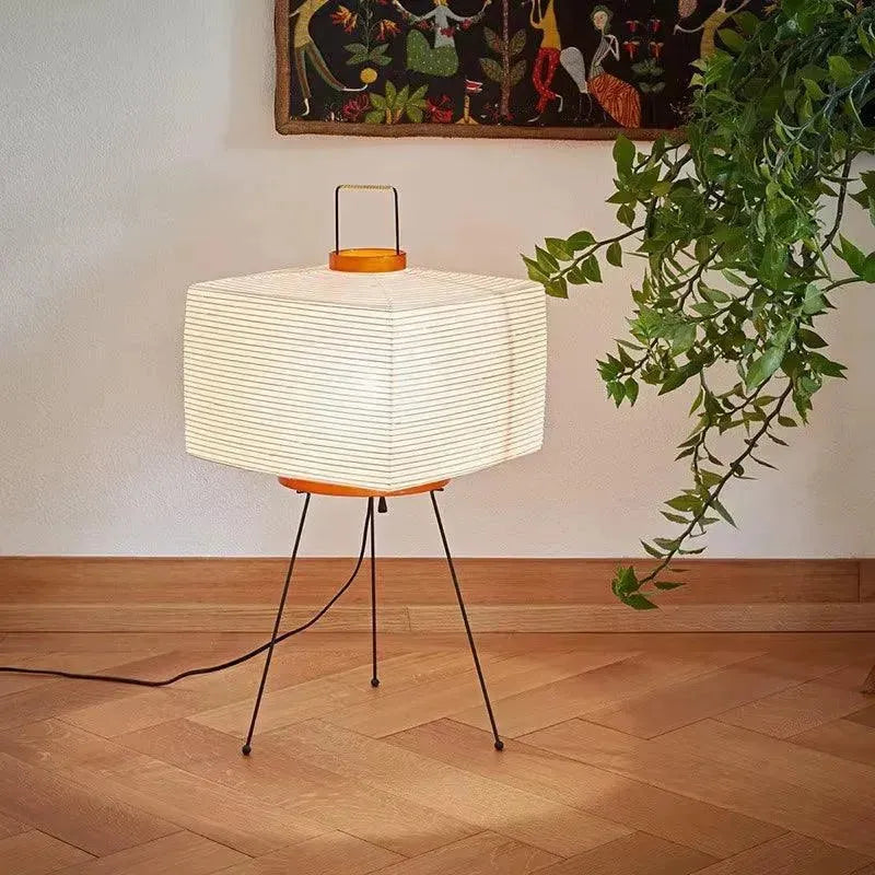 Lampe japonaise sur trépied avec abat-jour en papier de riz, lumière douce.