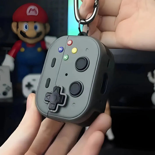 Coque AirPods noire en forme de manette retro accrochée à un mousqueton, tenue en main.