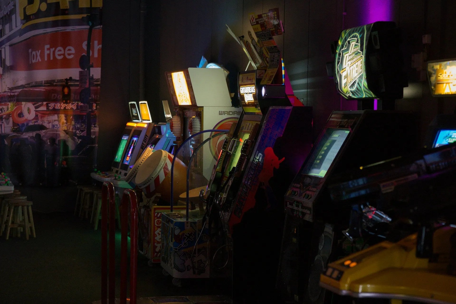 Salle d’arcade rétro colorée avec machines, jeux lumineux et ambiance néon, utilisée en arrière-plan pour mettre en valeur un produit au style jeu vidéo vintage