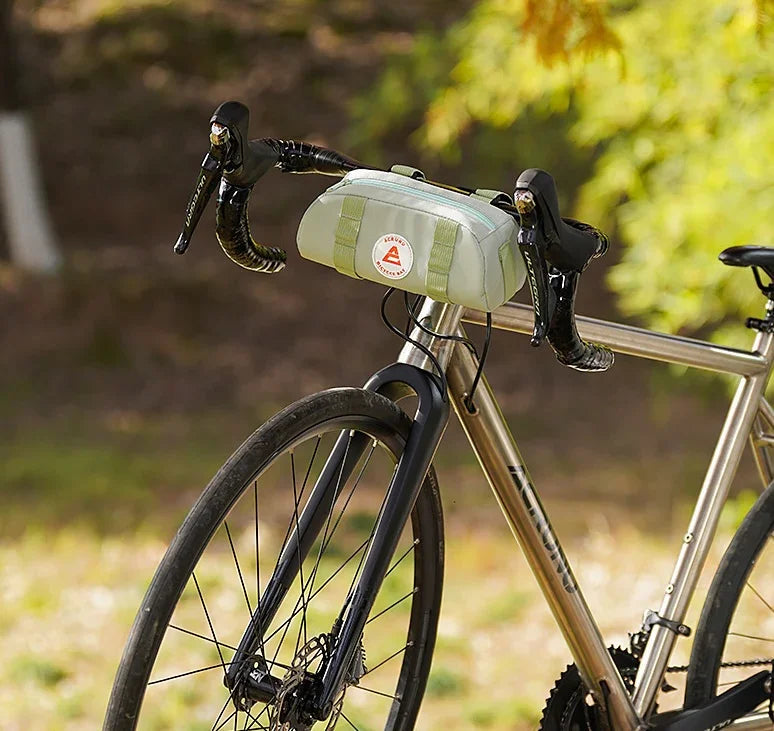 Vue latérale d’un sac guidon vert pastel sur vélo en extérieur – style épuré et discret