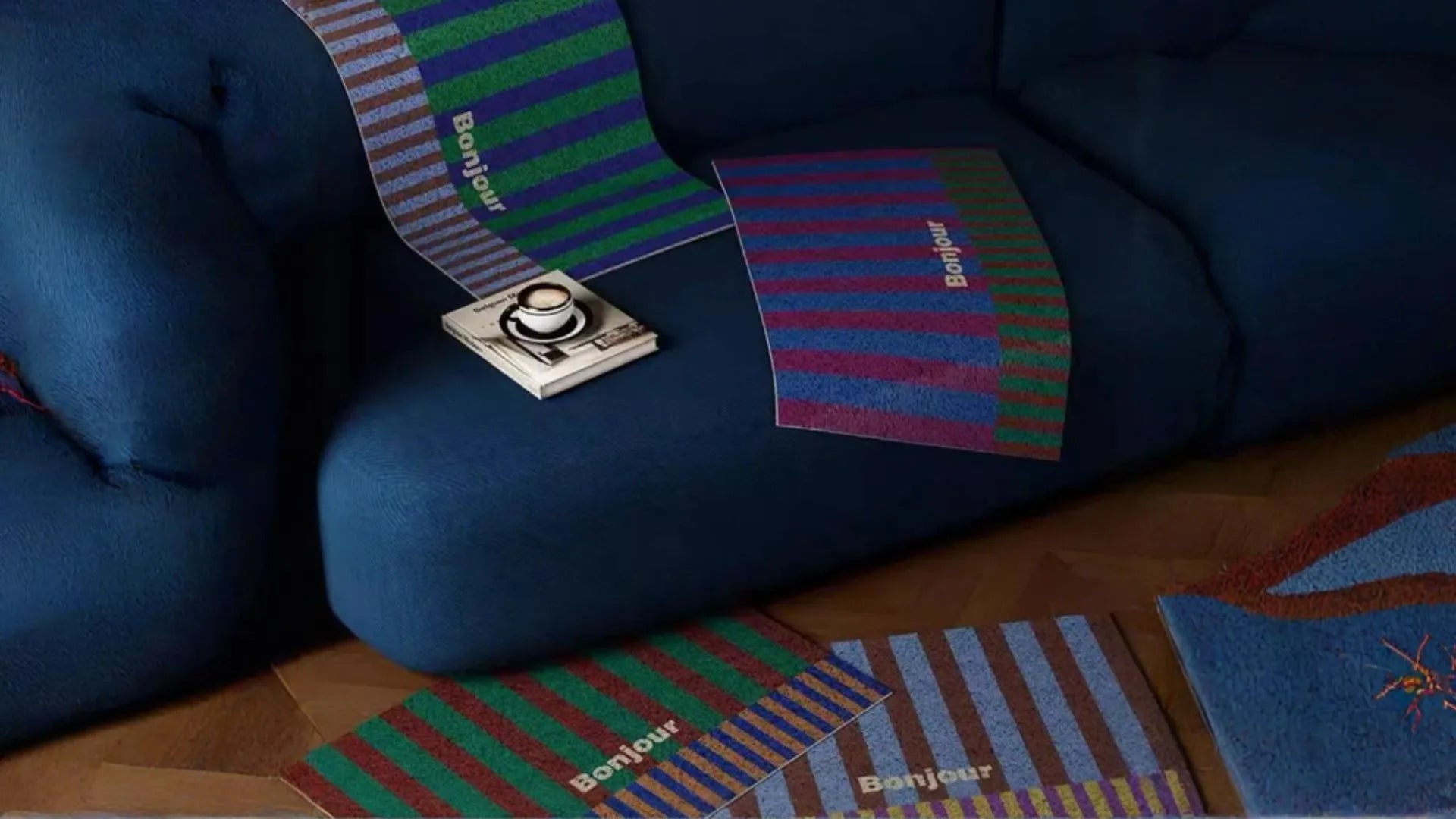 plusieurs tapis paillasson Bonjour aux motifs différents posés sur canapé et sol pour présentation coloris