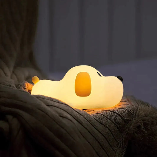 veilleuse enfant illuminée en forme de chiot allongé sur une couverture