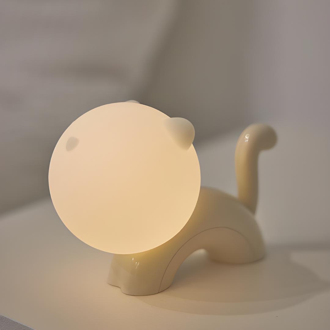 veilleuse chat en silicone et abs allumée posée sur une table de chevet