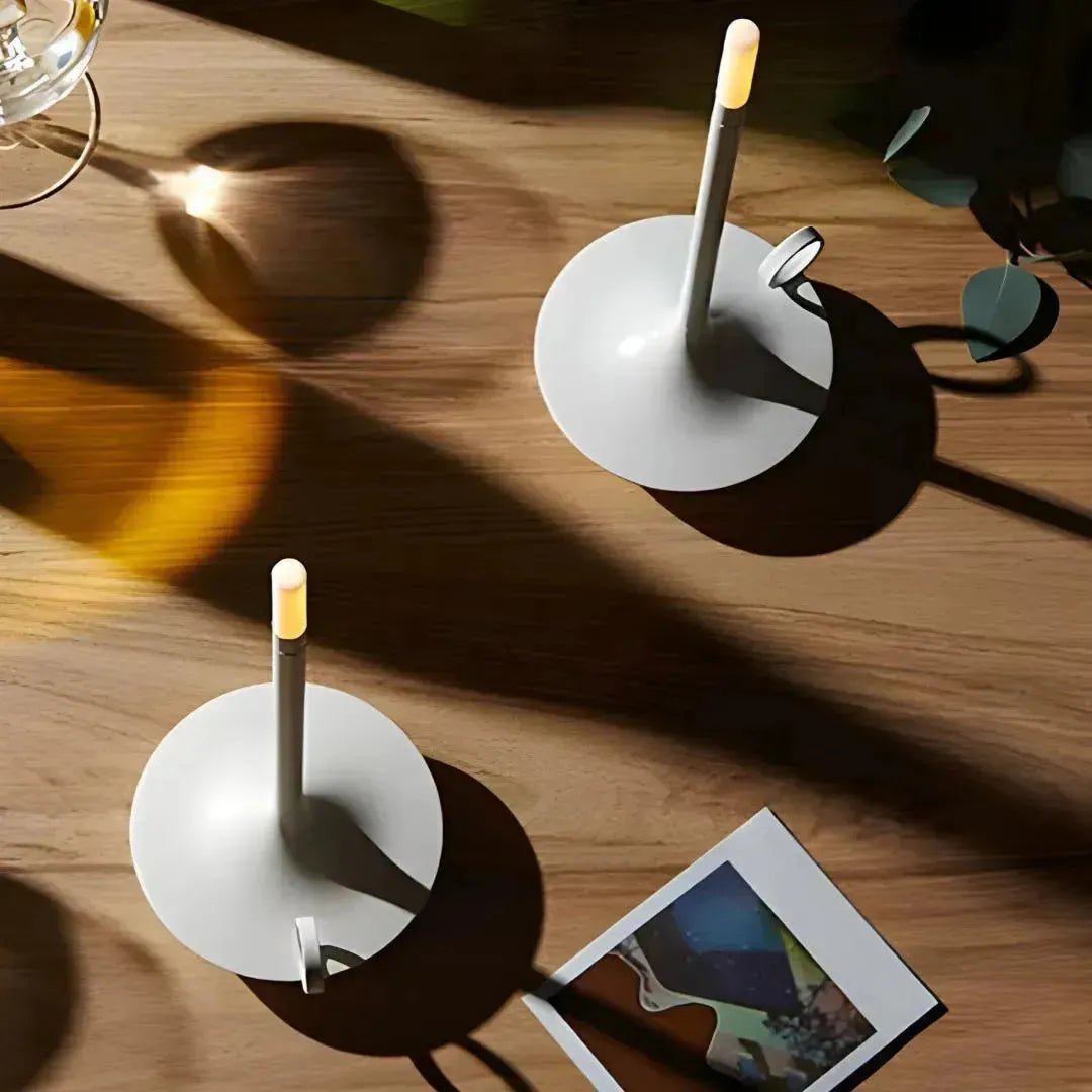 Lampe blanche style bougie avec finitions métalliques.