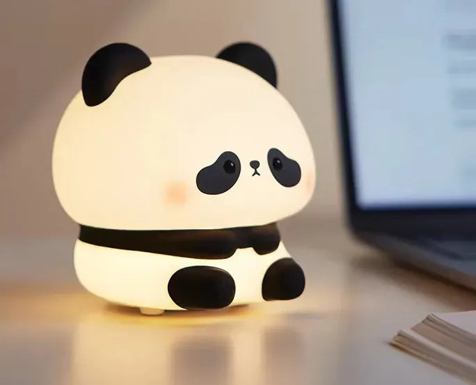 veilleuse panda assis sur un bureau à coté d'un ordinateur