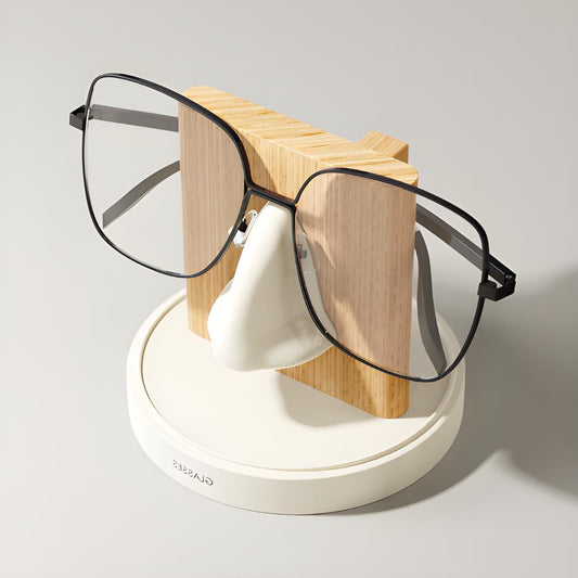 support lunettes blanc et bois clair avec paire de lunettes noire sur fond neutre