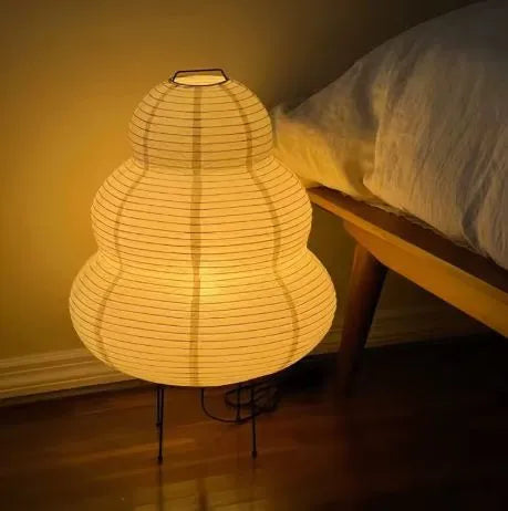 lampe papier à coté d'un lit allumée la nuit