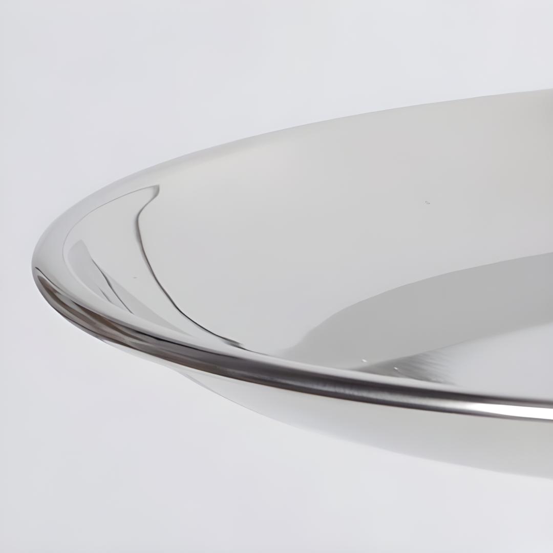 détail bord arrondi d’un plateau métal finition brillante, vue rapprochée de la surface réfléchissante