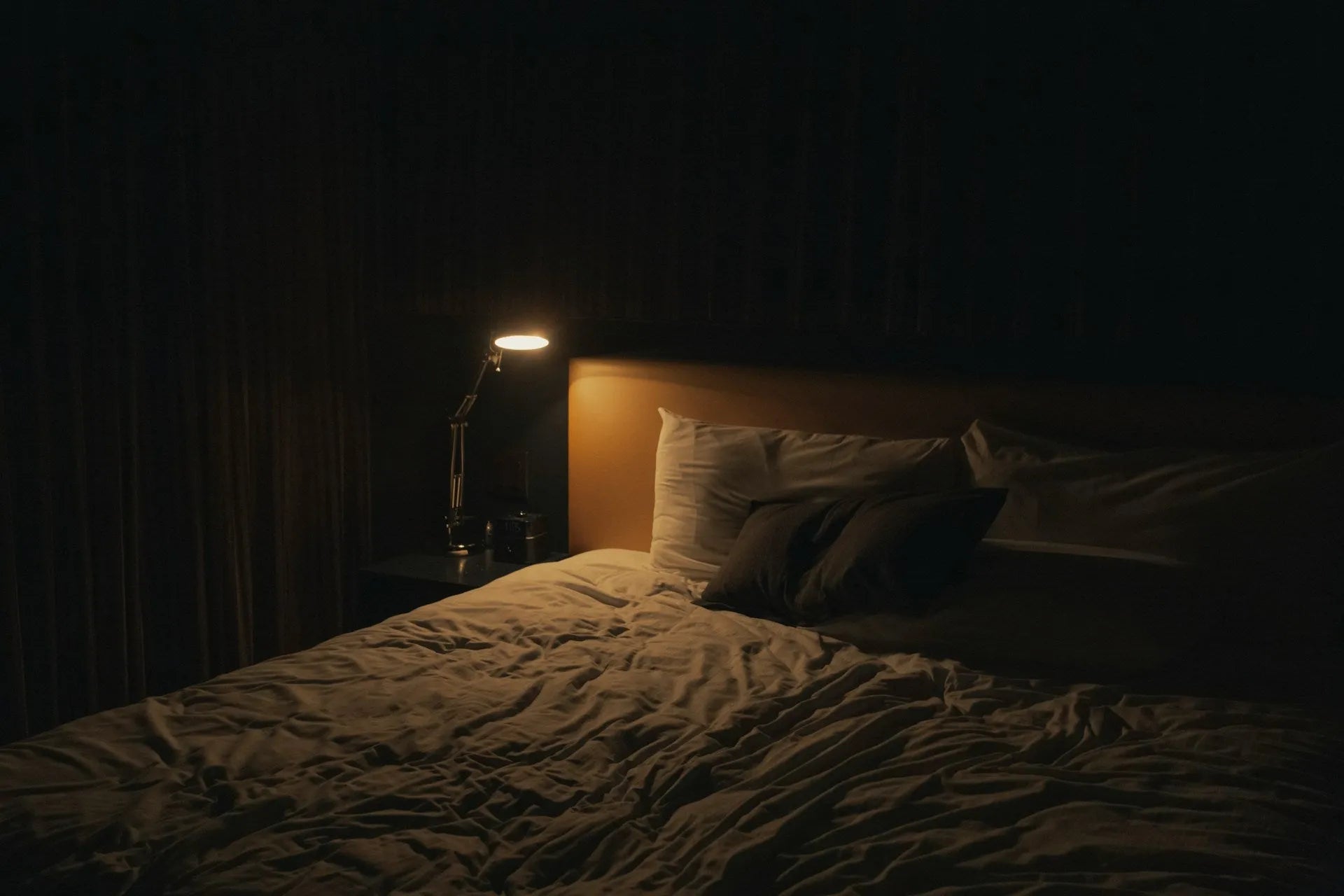 Ambiance de nuit dans une chambre avec éclairage doux et objet lumineux d’appoint sur table de chevet