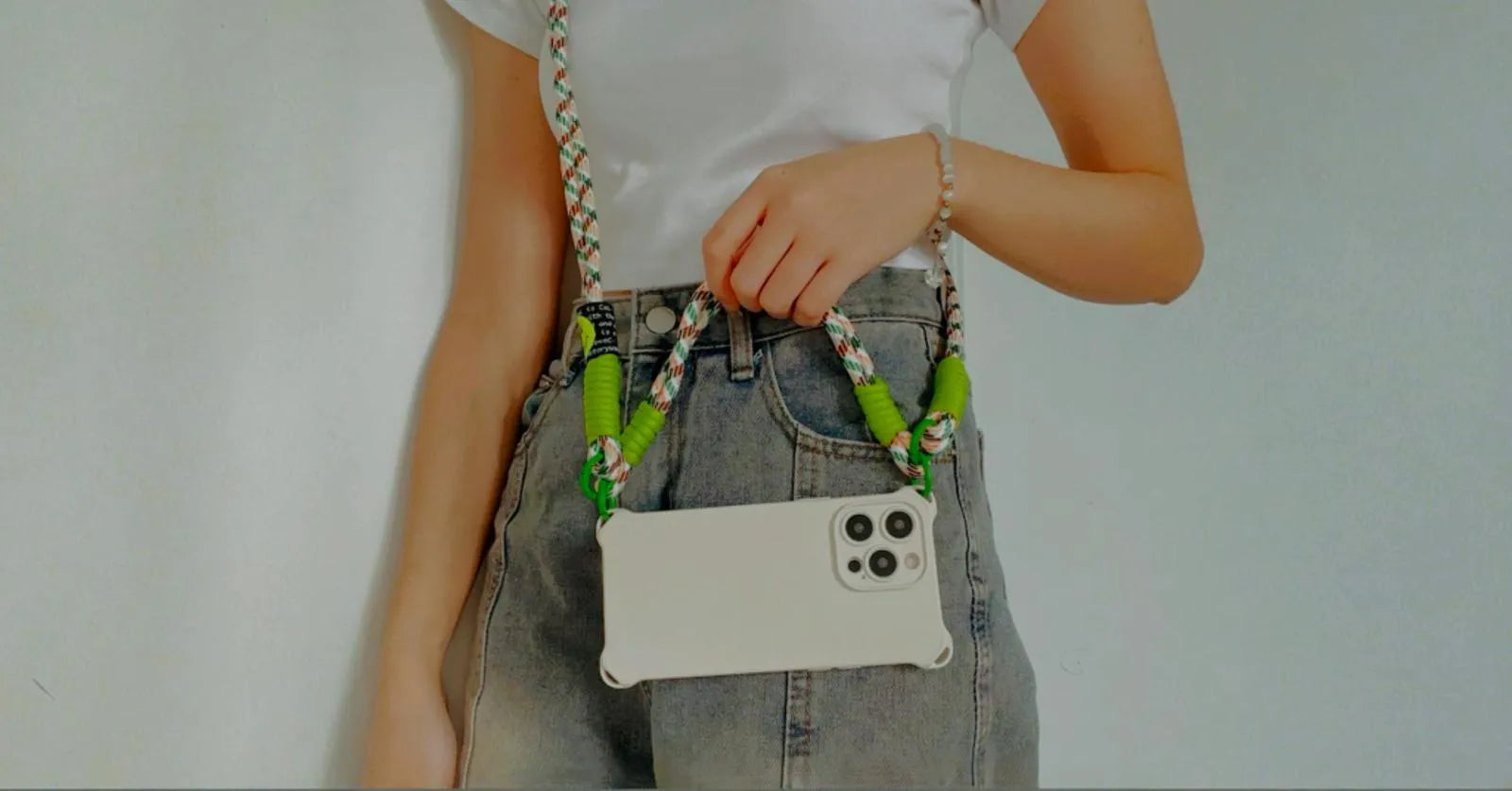 Coque crème portée façon bandoulière, tenue en main, vue en mode paysage