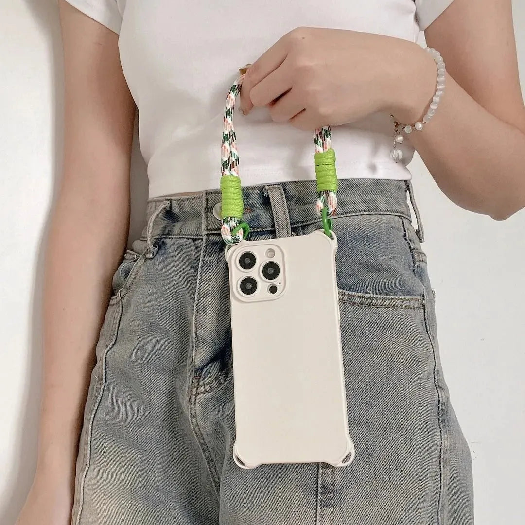 Coque crème portée en main, position verticale contre un jean