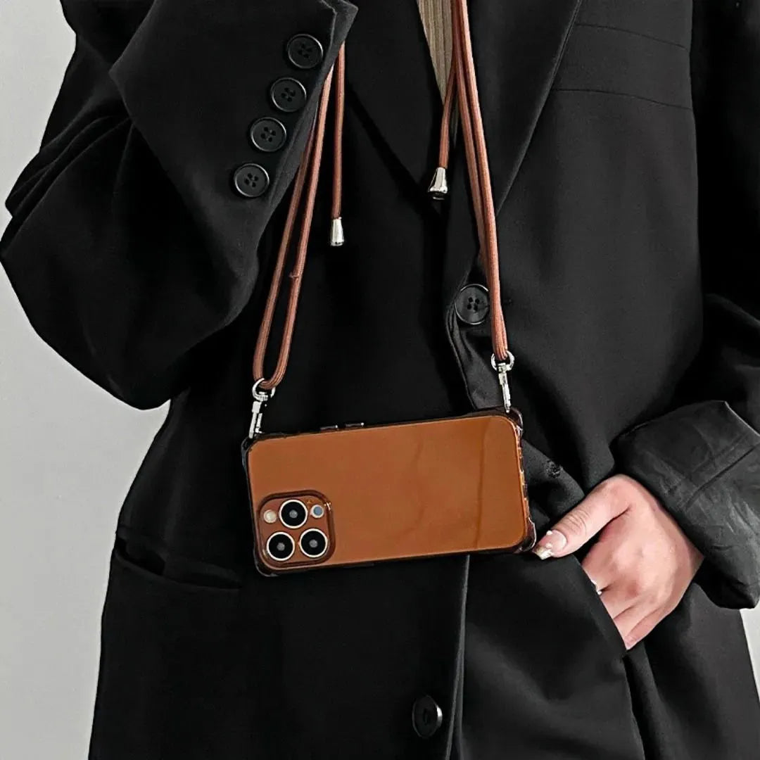 Coque iPhone marron suspendue en bandoulière sur une veste noire