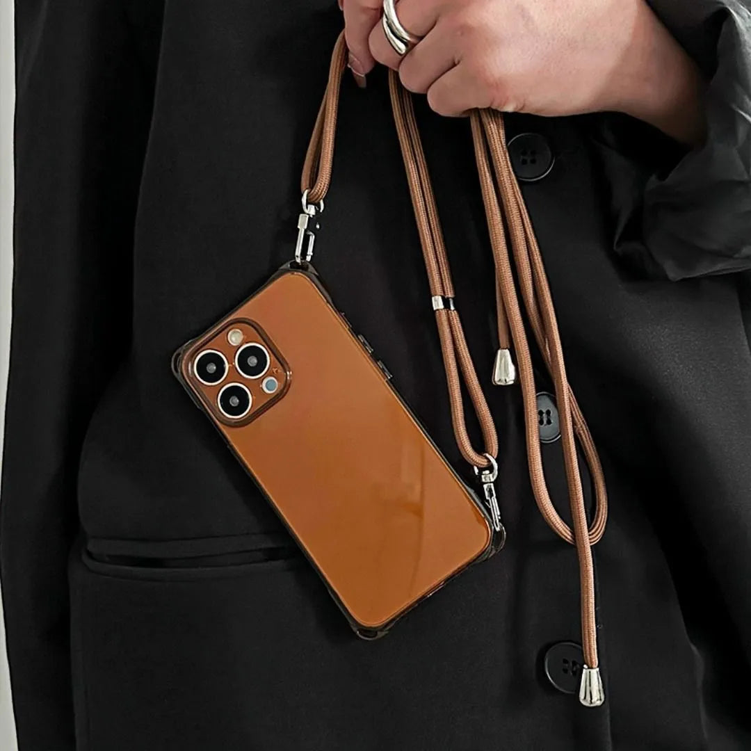 Coque iPhone marron tenue à la main, cordon long enroulé