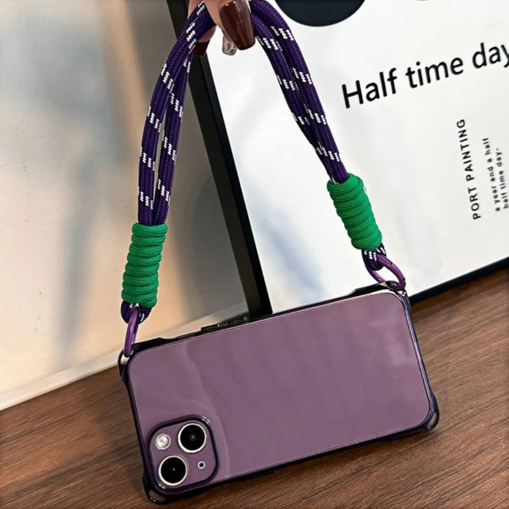 Coque iPhone violette avec cordon violet et vert tenue par une main, en position horizontale