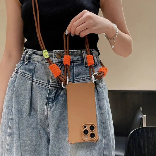 Coque marron portée autour du cou, tenue à la main avec cordon marron et attaches orange