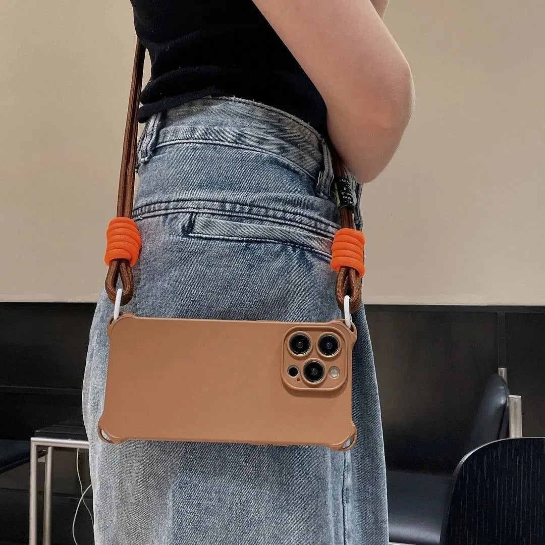 Coque marron portée en bandoulière avec jean taille haute, haut noir, cordon orange
