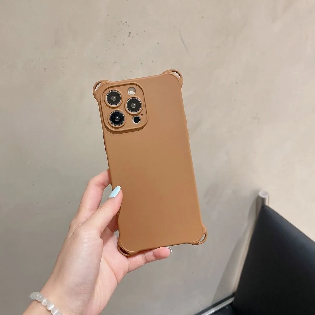 Coque marron tenue en main, vue arrière sur triple objectif