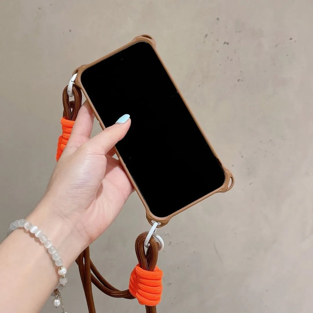 Coque marron vue de face tenue en main, cordon marron et attaches orange visibles
