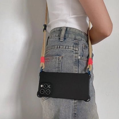 Coque noire portée en bandoulière à l’arrière, cordon jaune fluo avec attaches roses et anneaux bleus