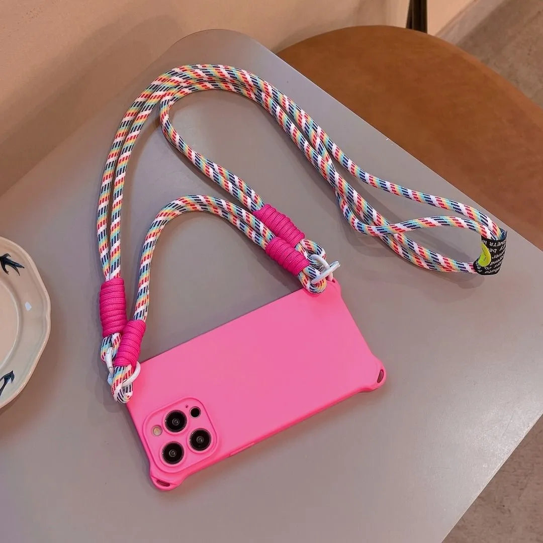 Coque rose fluo posée sur une table avec cordon arc-en-ciel bien visible