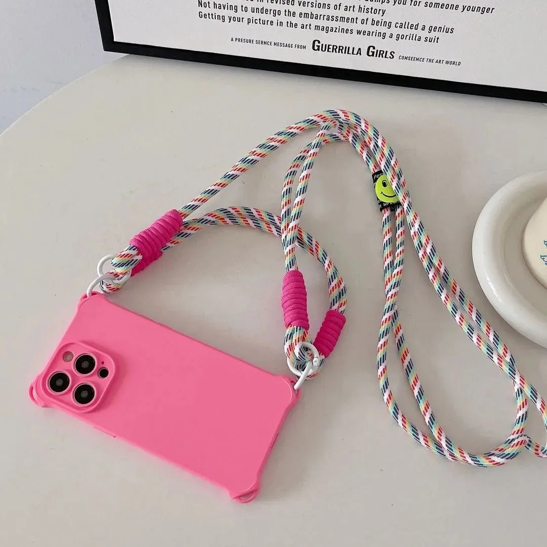 Coque rose fluo posée à plat sur une table, cordon arc-en-ciel visible avec smiley