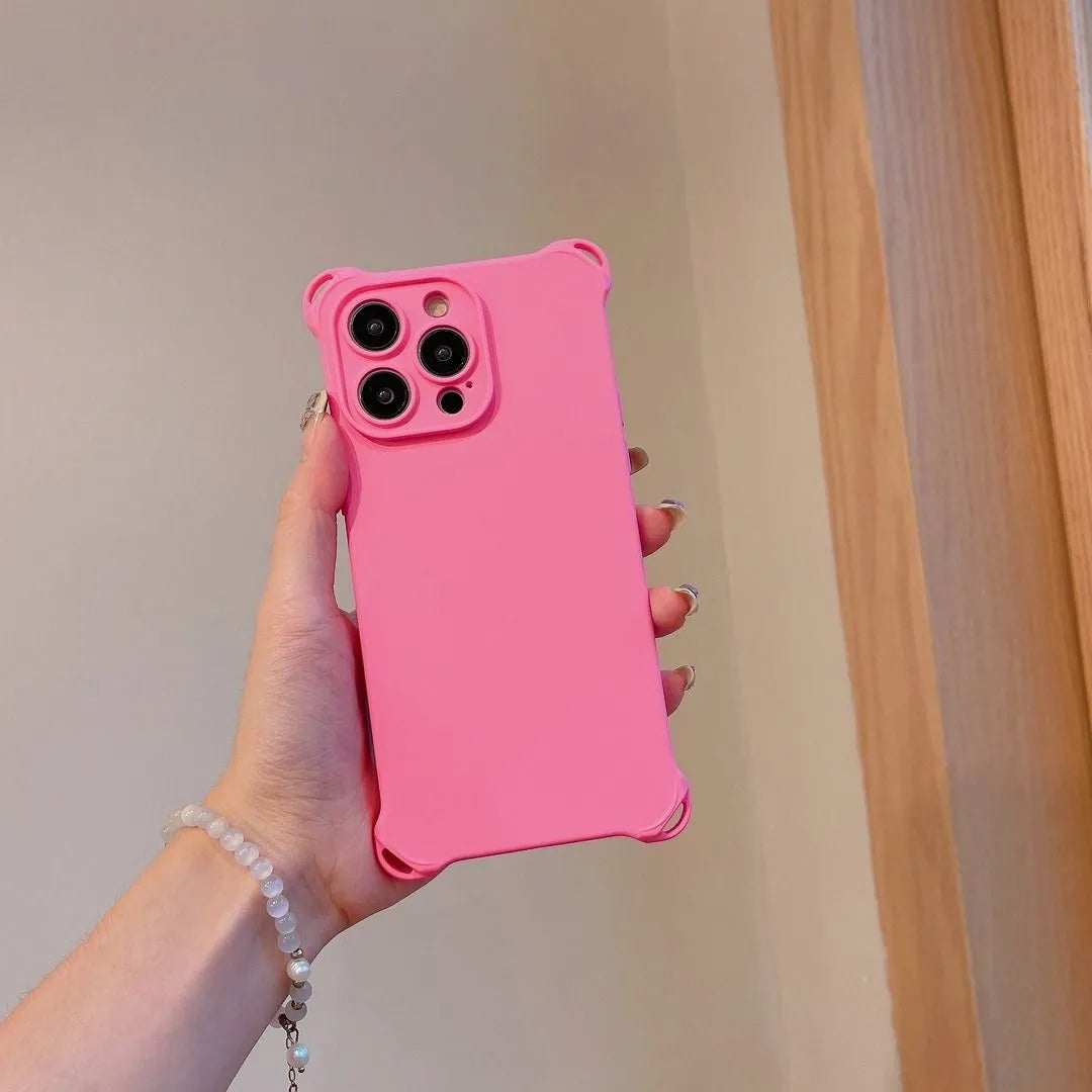 Coque rose fluo tenue en main, vue arrière avec fond bois clair