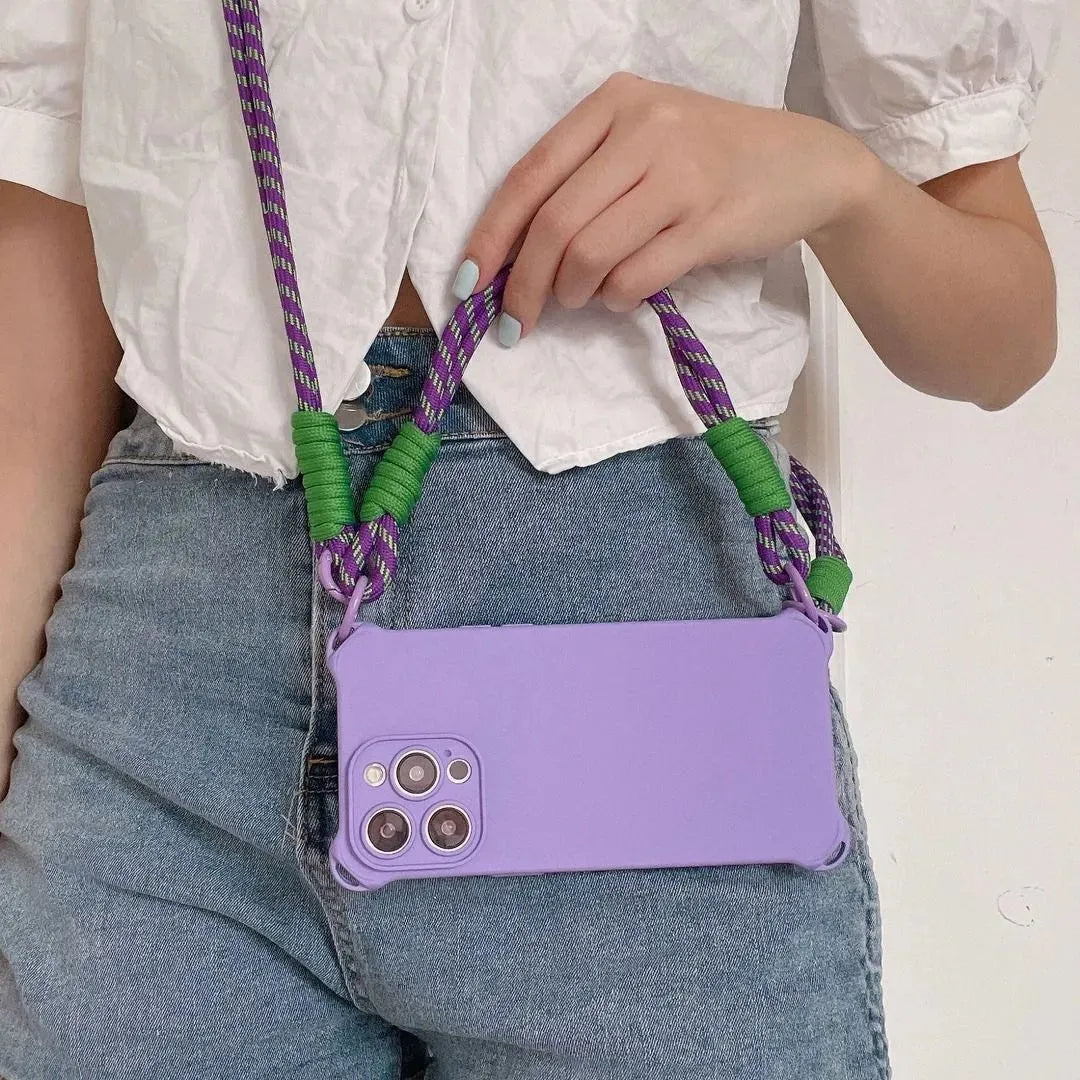 Coque violette portée en bandoulière avec cordon violet et vert – main posée