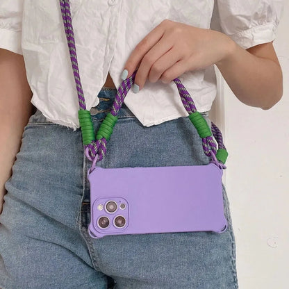 Coque violette portée en bandoulière avec cordon violet et vert – main posée