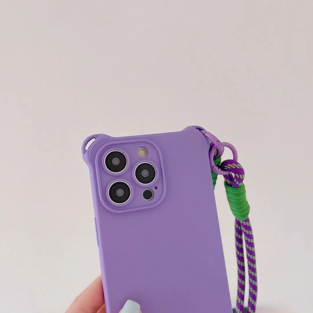 Coque violette en main avec cordon violet et vert, vue sur appareil photo