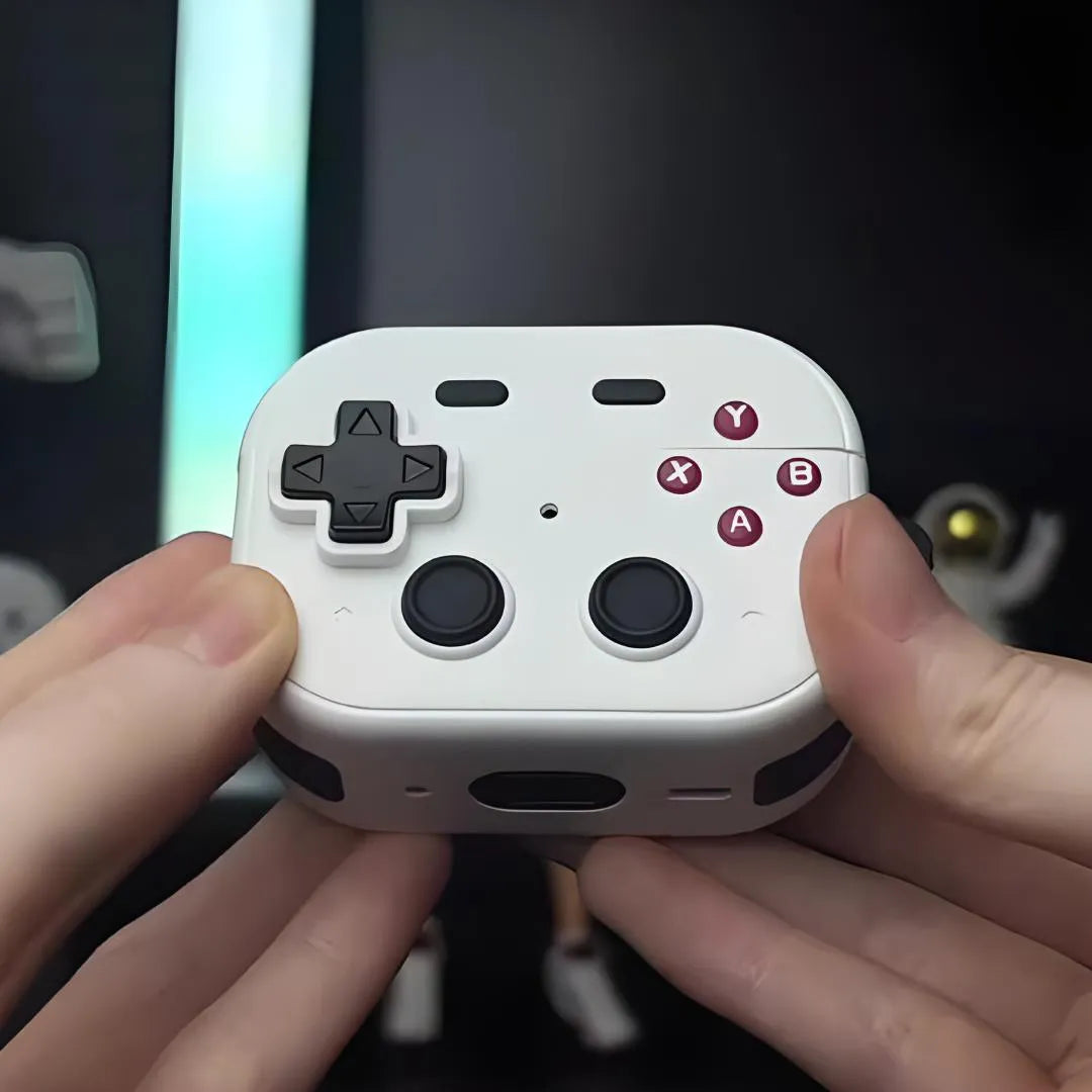 Housse AirPods Pro blanche en forme de manette de jeu avec boutons rouges, tenue en main.