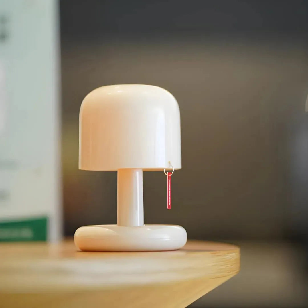 petite lampe fat boy blanche sur une table en bois