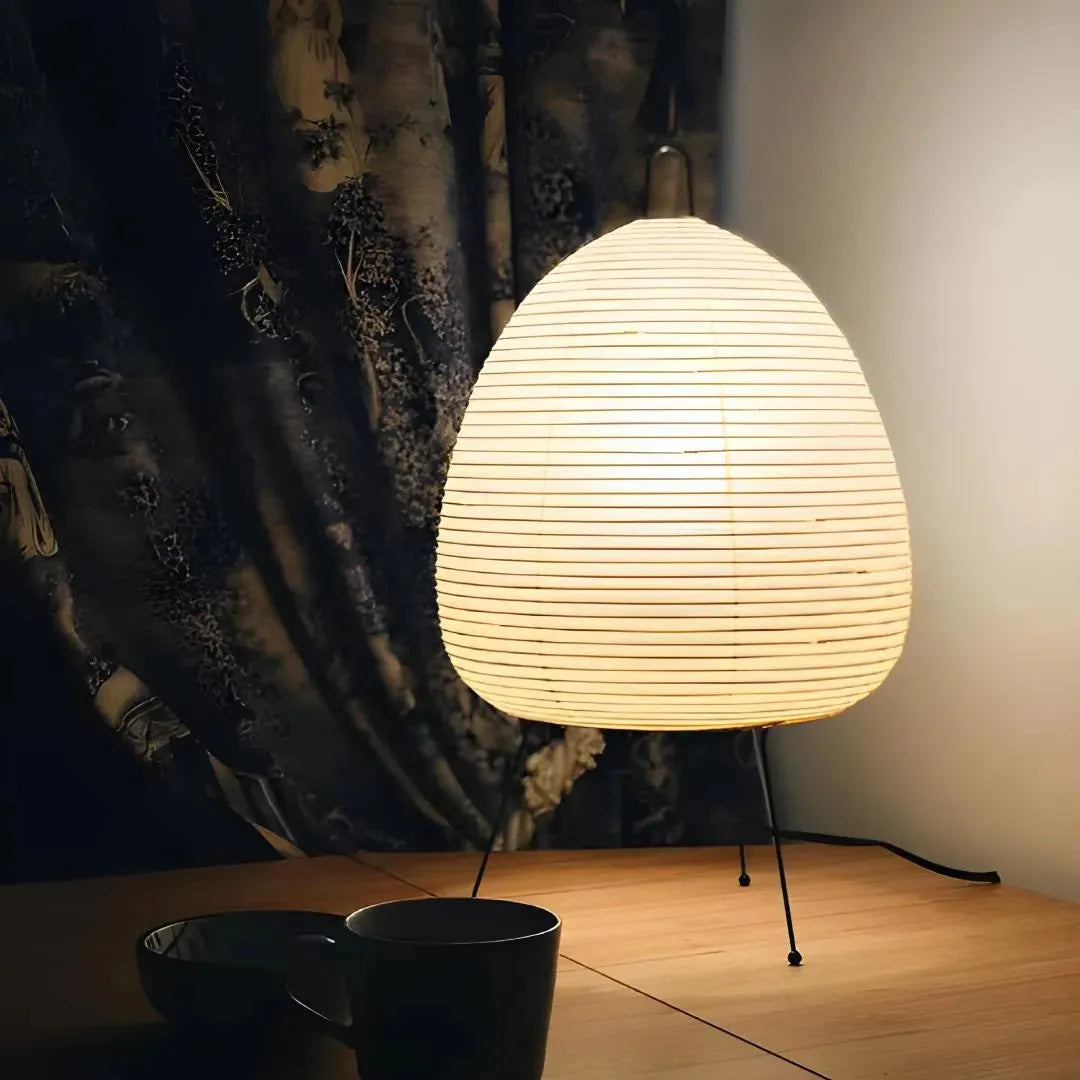 petite lampe papier posée sur une table devant un rideau