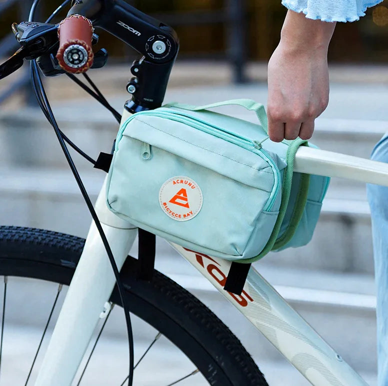 Cycliste tenant un sac de cadre vert pastel – sac vélo pratique pour trajets quotidiens