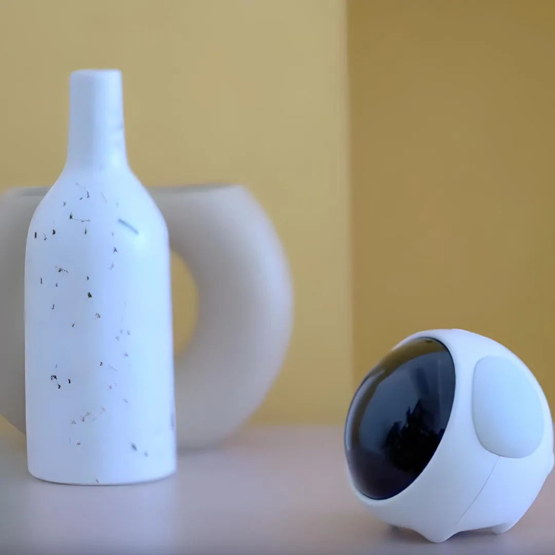 Réveil design blanc au style moderne, posé à côté de vases décoratifs