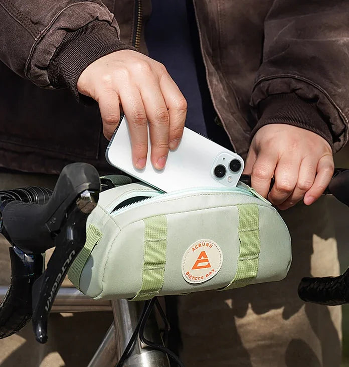 Cycliste installant un sac de guidon vert – sacoche pratique pour objets du quotidien