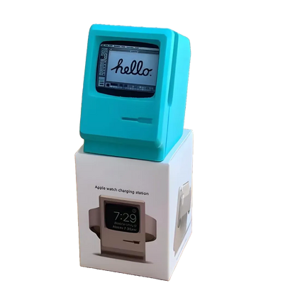 Support de recharge Apple Watch couleur turquoise au design Macintosh Classic, posé sur son packaging, sans fond